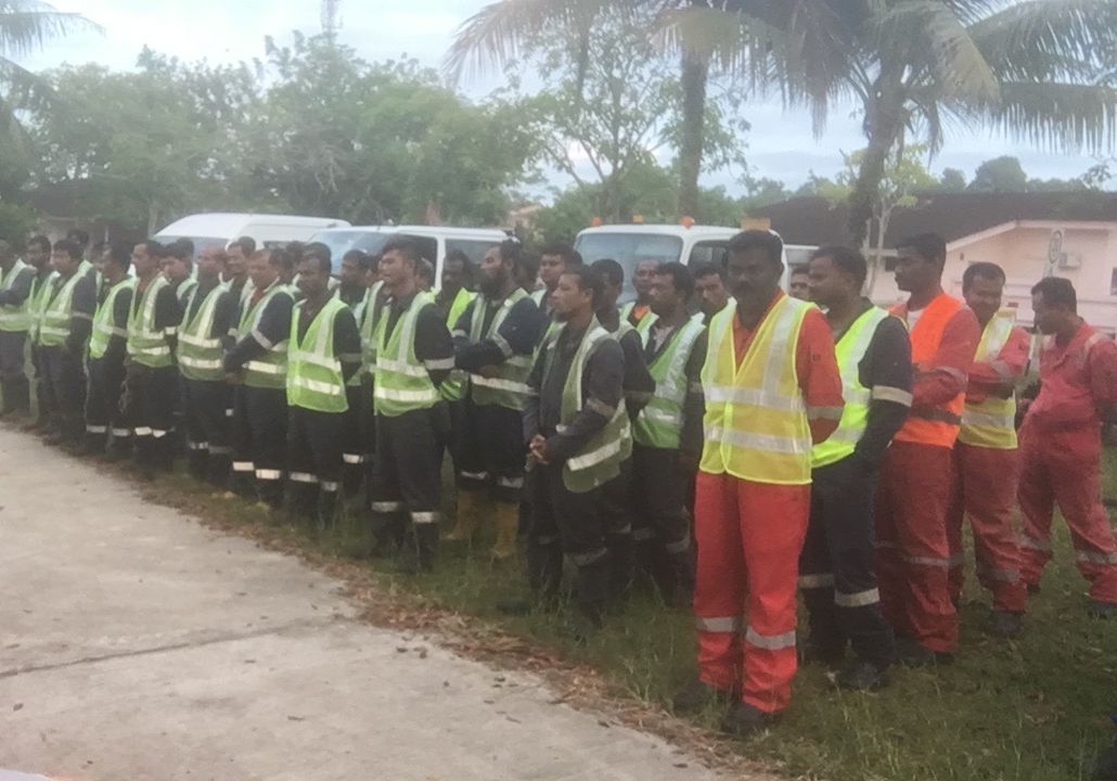 SHYT crews lined up in hi-vis vests and coveralls for a pre-job briefing