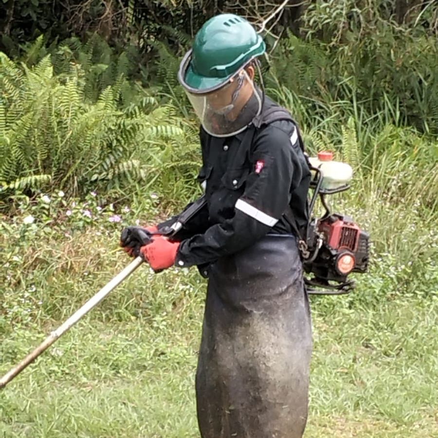 Brush cutter operator in face shield and apron