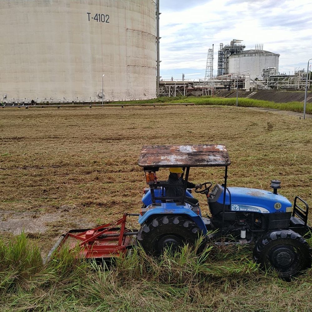 Tractor mowing at an LNG plant